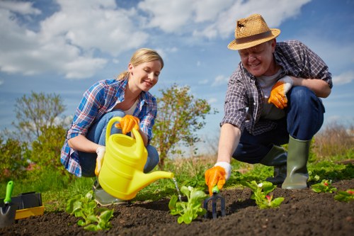 Worker demonstrating safe tool use during garden maintenance